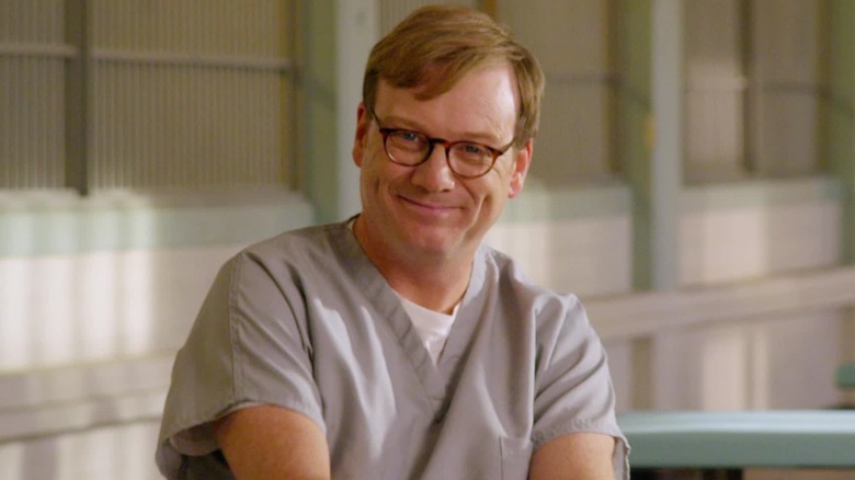 Andy Daly as Forrest MacNeil, smiling in prison on Review