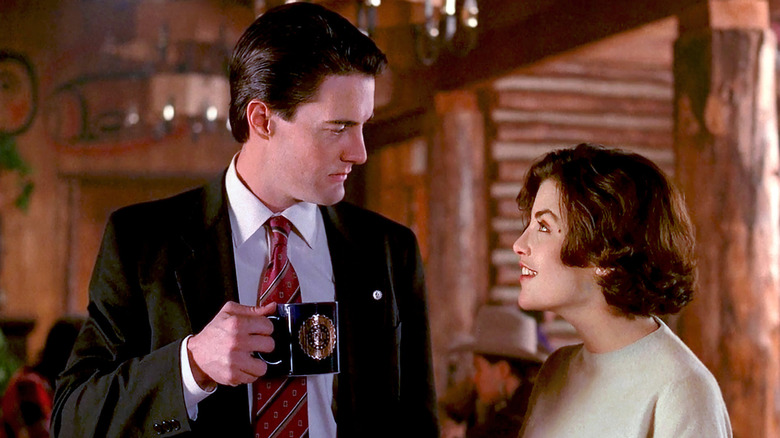 Kyle MacLachlan and Sherilyn Fenn as Dale Cooper and Audrey Horne, talking in a cabin on Twin Peaks
