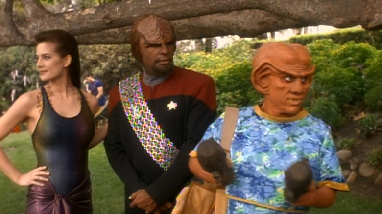 Terry Farrell as Jadzia Dax in a bathing suit, Michael Dorn as Worf in his Starfleet uniform, and Armin Shimerman as Quark in beach attire on Star Trek: Deep Space Nine