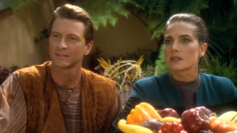 Brett Cullen as Deral and Terry Farrell as Jadzia Dax sitting at a table with fruit on Star Trek: Deep Space Nine
