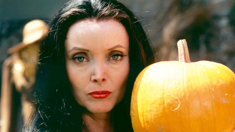 Carolyn Jones as Morticia Addams, holding a pumpkin, in a publicity still for 1977's Halloween with the New Addams Family.