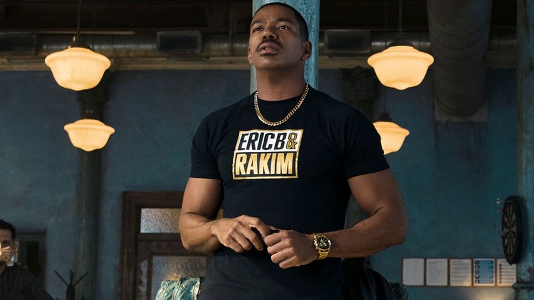 Mother's Milk looks quizzically ahead while wearing a black tshirt with a gold chain in "The Boys"