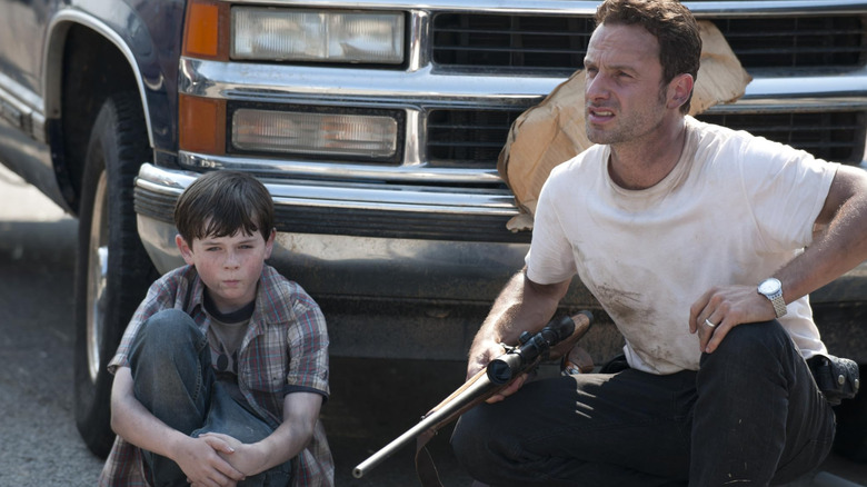 Early-seasons Carl and Rick hiding from walkers in The Walking Dead