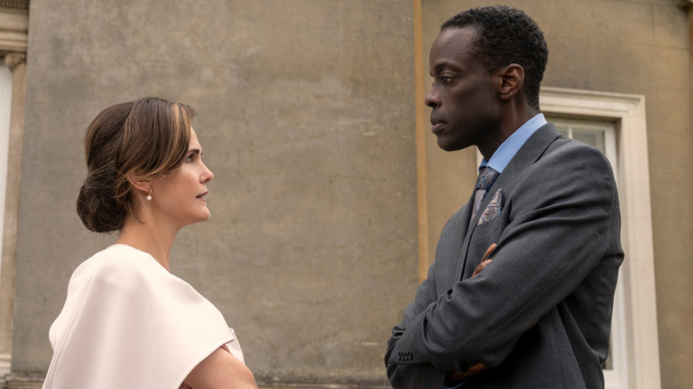 Kate Wyler and Stuart Heyford staring at each other with their arms crossed in The Diplomat