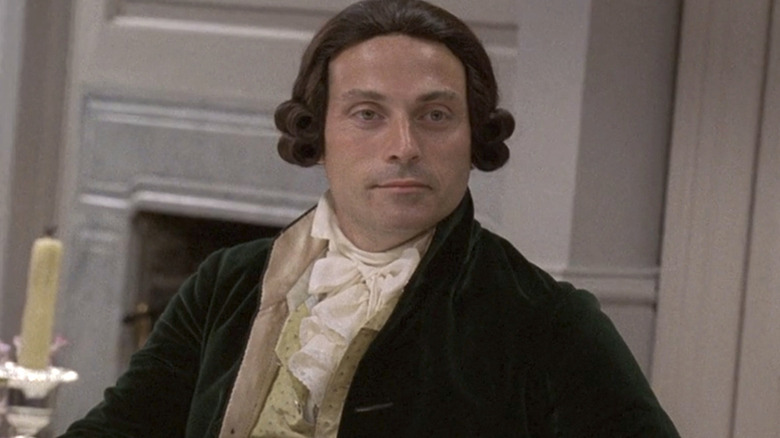 Alexander Hamilton in a green jacket looking straight ahead
