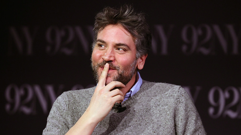 Josh Radnor making a cheeky face during an on-stage appearance