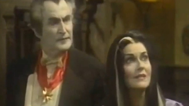 Howard Morton as Grandpa with a grimace on his face standing next to Lee Meriwether as Lily on The Munsters Today