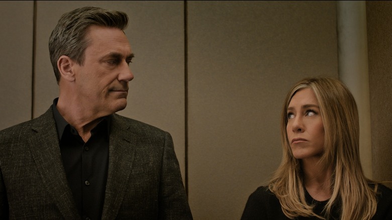 Jon Hamm as Paul and Jennifer Aniston as Alex look at each other meaningfully in The Morning Show