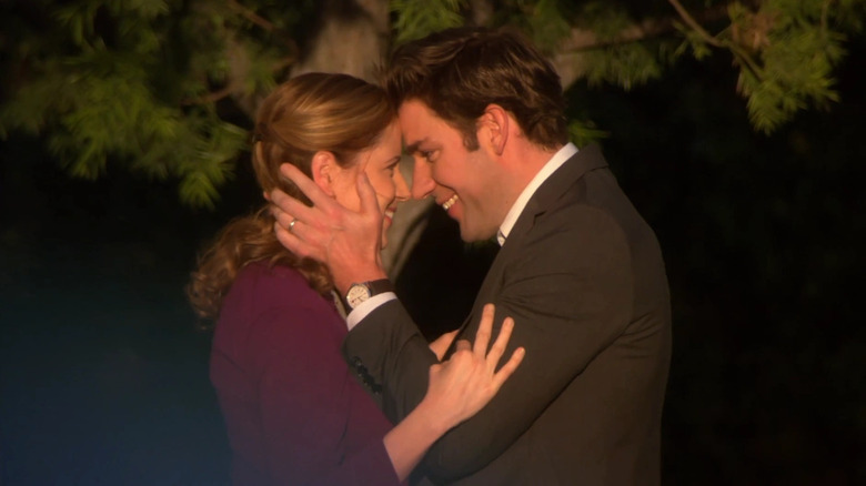 Jenna Fischer and John Krasinski as Jim Halpert and Pam Beasley, smiling at each other and embracing on The Office.