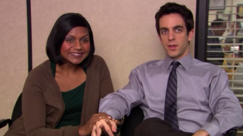 BJ Novak and Mindy Kaling as Ryan Howard and Kelly Kapoor, holding hands on The Office.