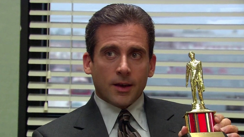 Steve Carell as Michael Scott, holding up a Dundie Award on The Office.
