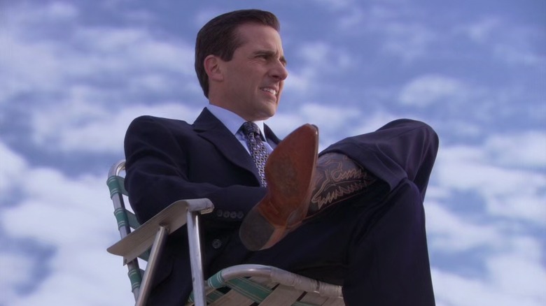 Michael Scott as Steve Carell, sitting on the roof of Dunder Mifflin on The Office.