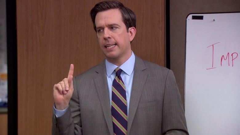 Ed Helms as Andy Bernard, leading a conference room meeting on The Office.