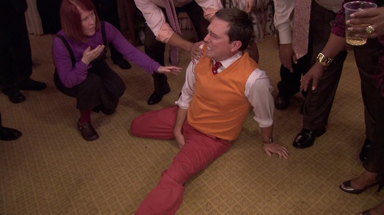 Andy Bernard (Ed Helms) painfully holds his crotch on the ground in The Office