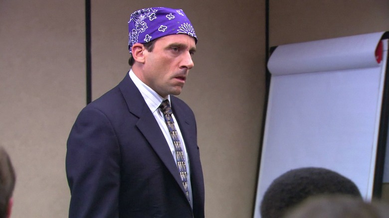Michael Scott (Steve Carell) scowls while wearing a purple bandana in The Office
