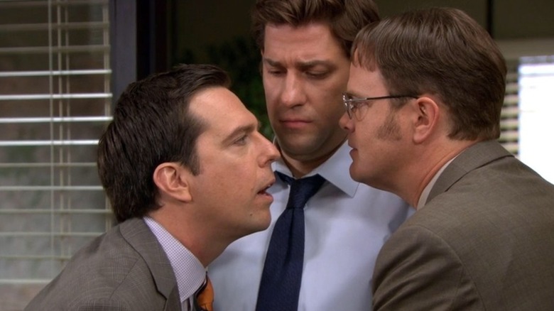 Ed Helms as Andy Bernard gets in the face of Rainn Wilson as Dwight Schrute while John Krasinski as Jim Halpert watches on The Office
