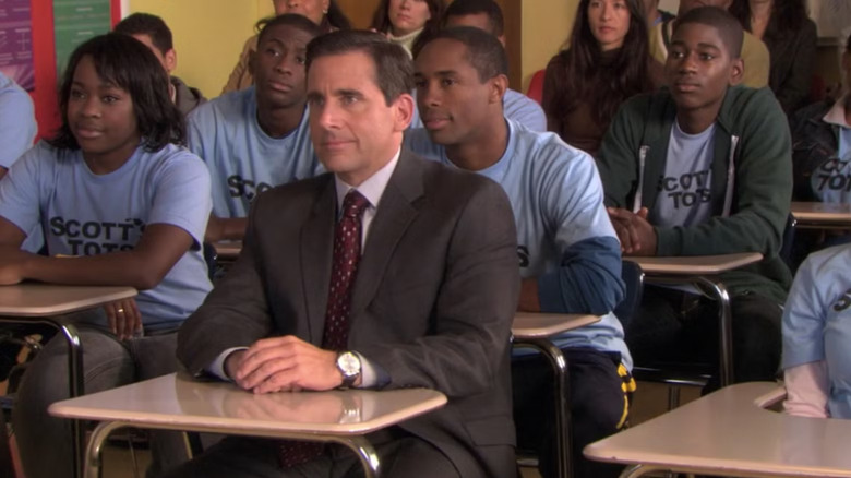 Steve Carell as Michael Scott sits with students on The Office