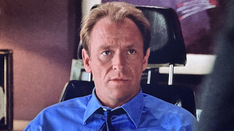 Arnie Becker in a blue shirt sitting in a black chair in L.A. Law