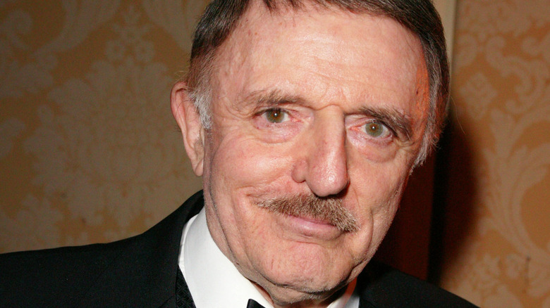 John Astin smiling in a suit and bowtie