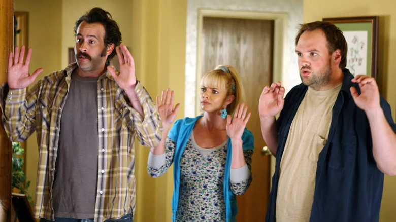 Earl (Jason Lee), Randall (Ethan Suplee), and Joy (Jaime Pressly) hold their hands up as they are taken hostage inside their home in "My Name Is Earl"