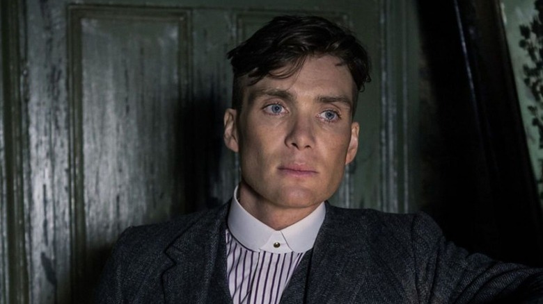 Tommy Shelby standing in front of a door in "Peaky Blinders"