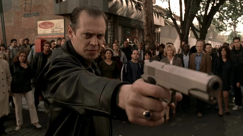 Steve Buscemi as Tony Blundetto, aiming a gun in front of a crowd in The Sopranos.