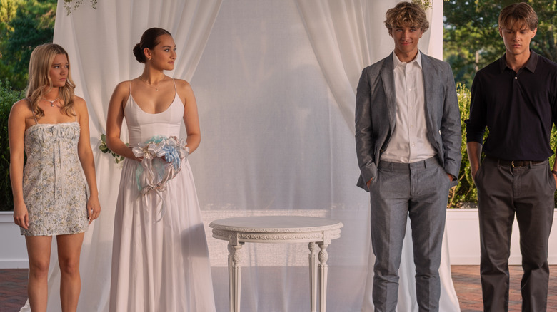 Taylor, Belly, Jeremiah, and Conrad stand in front of a white curtain in "The Summer I Turned Pretty" (2022-2025)