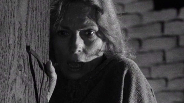 A woman (Agnes Moorehead) stares in shock while holding open a door in The Twilight Zone