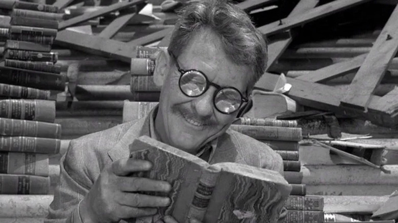 Henry Bemis (Burgess Meredith) contentedly reads a book in The Twilight Zone