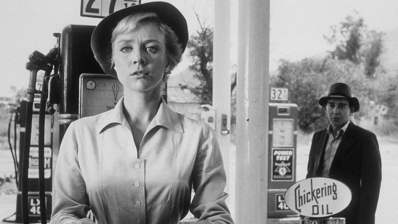 Nan Adams (Inger Stevens) stands at a gas station as a hitchhiker (Leonard Strong) approaches her from behind in The Twilight Zone