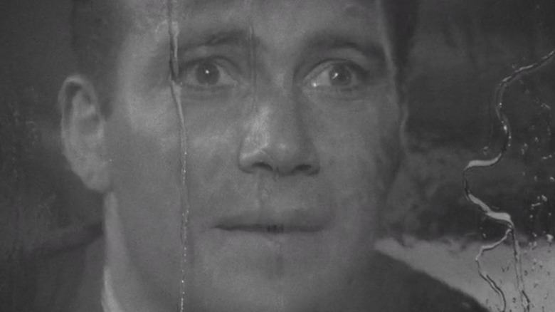 Robert Wilson (William Shatner) looks in shock out a rainy window in The Twilight Zone