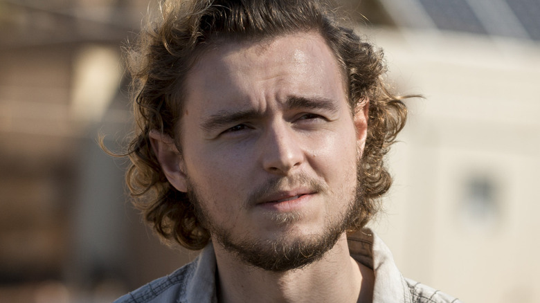 Callan McAuliffe as Alden, smiling in The Walking Dead.