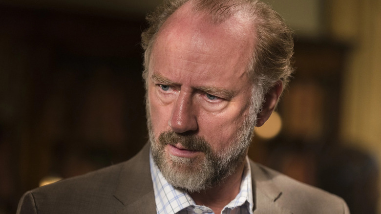 Xander Berkeley as Gregory, looking down in The Walking Dead.