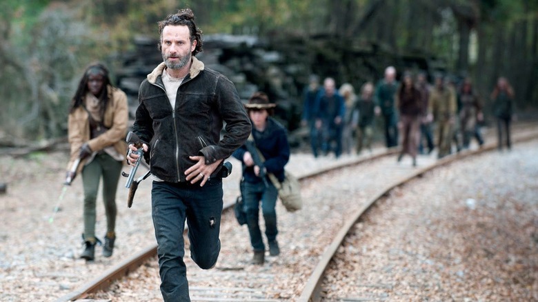 Rick Grimes (Andrew Lincoln) leads Michonne (Danai Gurira) and Carl Grimes (Chandler Riggs) down railroad tracks on The Walking Dead