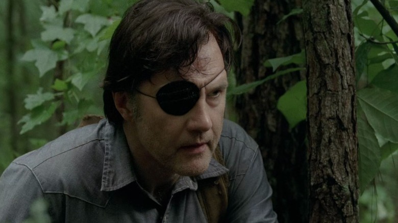 The Governor crouching down next to a tree on The Walking Dead S4E7