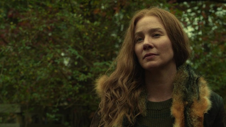 Leah standing among trees with a skeptical expression on The Walking Dead S10E18