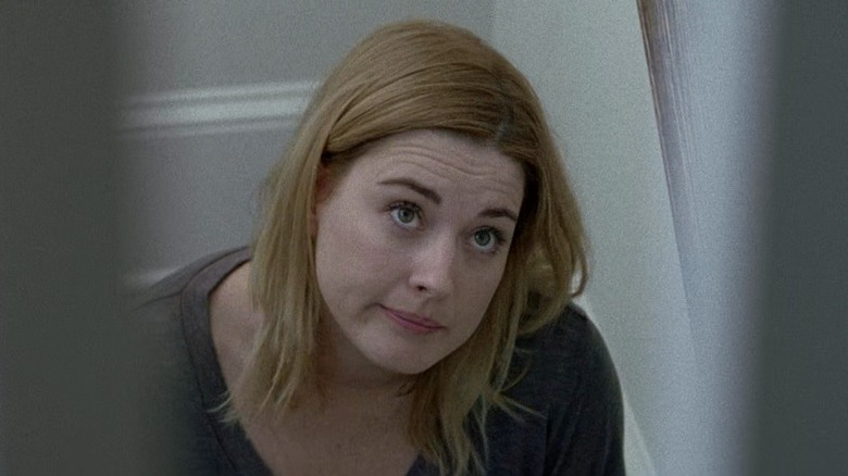 Jessie sitting on a staircase and looking up while compressing her lips on The Walking Dead S6E5