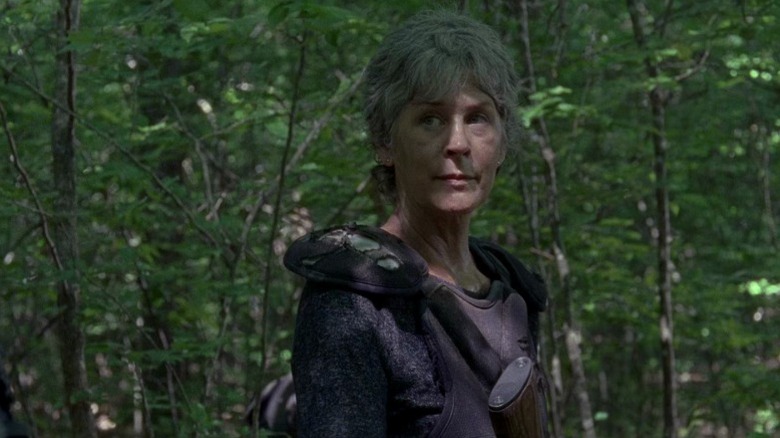 Carol standing in the forest and looking to her right on The Walking Dead S8E2