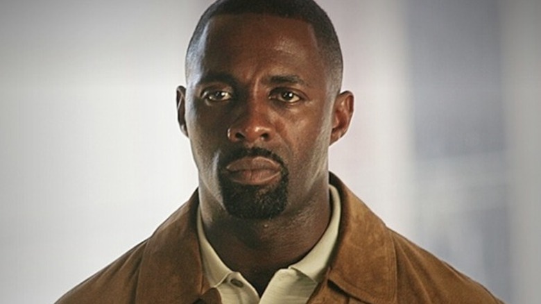 Idris Elba's Stringer Bell looking sad and wearing a brown leather jacket on The Wire