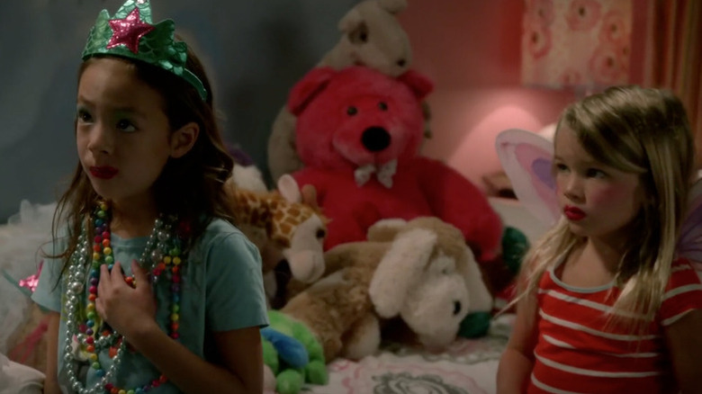 Lily (Aubrey Anderson-Emmons) and Megan (Raegan Revord) standing next to each other on "Modern Family"