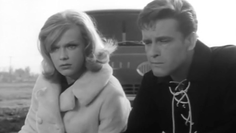 TV detective Honey West and sidekick Sam Bolt crouch by the roadside in the 1965 series.