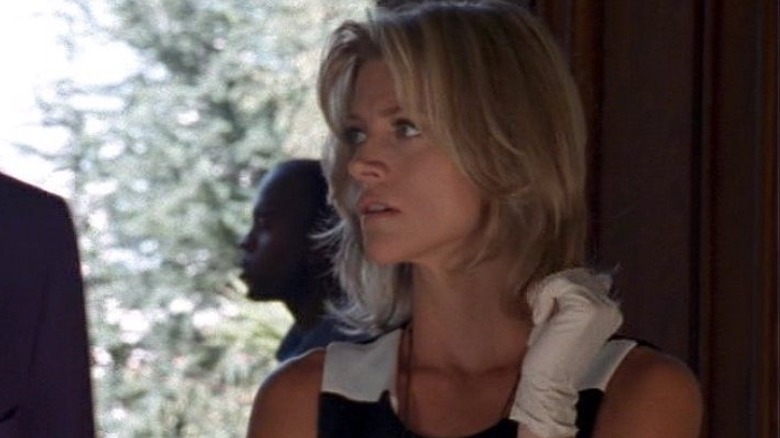 Detective Cassandra "Cassy" St. John looking off to her right while standing next to someone and observing a crime scene