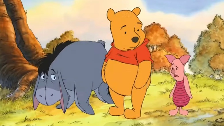 Eeyore looking sad next to Winnie the Pooh and Piglet
