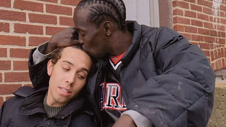 Michael K. Williams as Omar Little kissing the forehead of Michael Kevin Darnall as they sit outside in The Wire
