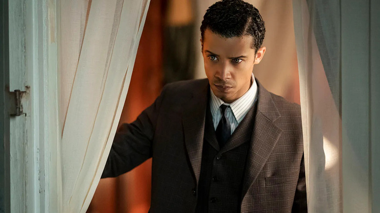 Jacob Anderson as Louis de Pointe du Lac, looking through a curtain in Interview with the Vampire.
