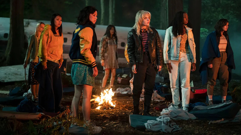 The Yellowjackets stand up around a fire in Yellowjackets.