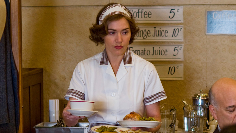 Mildred Pierce (Kate Winslet) holding plates of food in Mildred Pierce