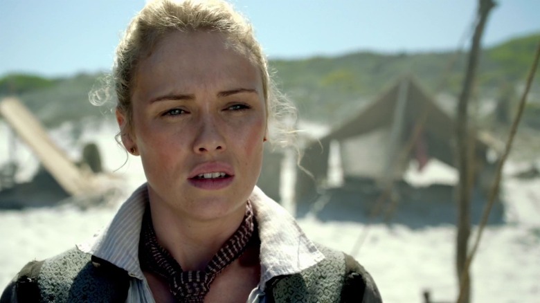 Eleanor Guthrie as Hannah New standing on beach in front of tents on Black Sails