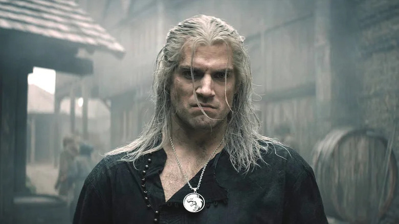 Henry Cavill with long white hair snarling as Geralt in The Witcher