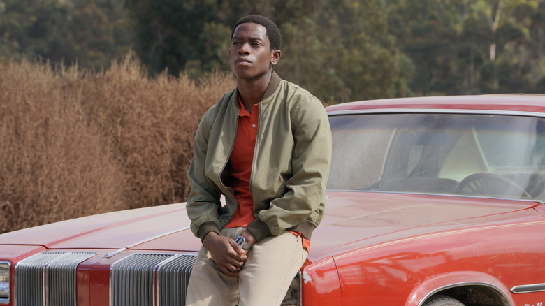 Franklin Saint (Damson Idris) sitting on a car in Snowfall